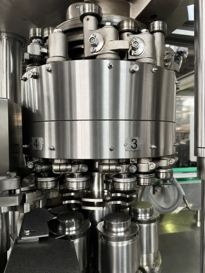 Close-up of rotary can seamer head and roll assemblies