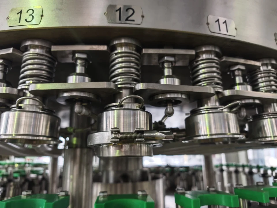 Automatic CIP cleaning cups secured beneath rotary filling valves.